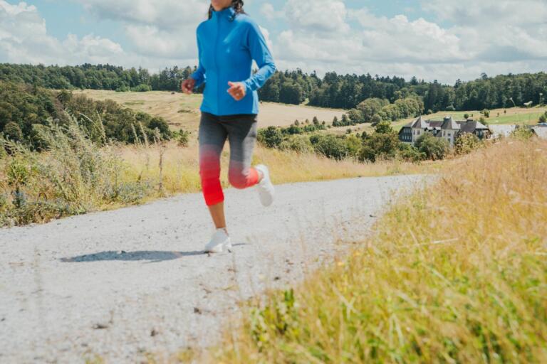 Eine Person joggt auf einem Schotterweg in der ländlichen des Hofgut Georgenthal.