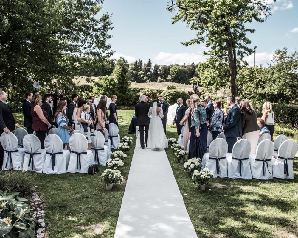 Ein Hochzeitspaar auf dem Weg zum Altar im idyllischen Außenbereich der Hochzeitslocation bei Wiesbaden Hofgut Georgenthal